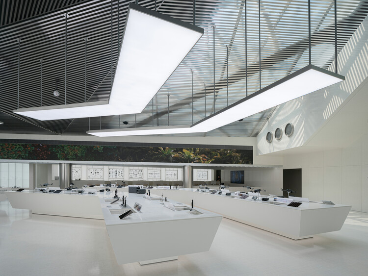 The lobby of a Shenzhen consumer-technology experience centre, product benches under suspended light panels.