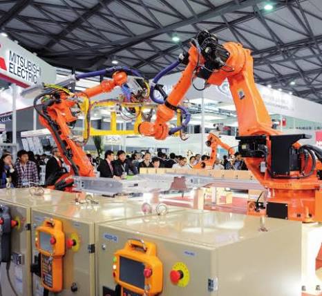 Industrial robot arms running a demonstration cell at a Shenzhen automation trade fair.